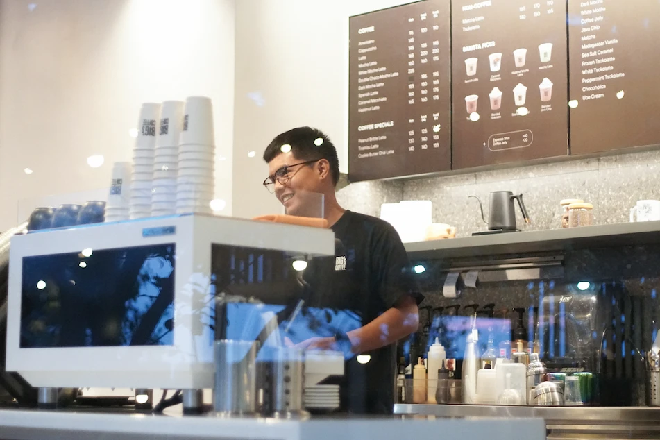 smilling bigs coffee employee on counter